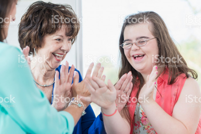 514514204-down-syndrome-girl-with-family-playing-games